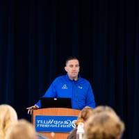 a speaker speaks to a crowd of students from behind a podium